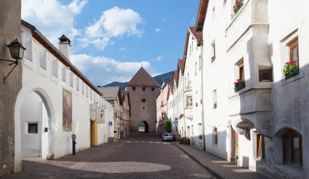Medieval street in Glurns, South Tyrol, with whitewashed houses and cobblestone paving