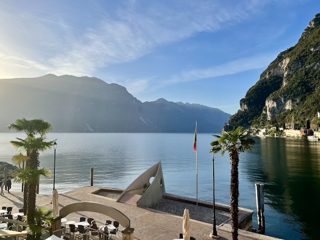 Picturesque waterfront of Riva del Garda on Lake Garda, with colorful buildings, boats, and mountain scenery in Northern Italy