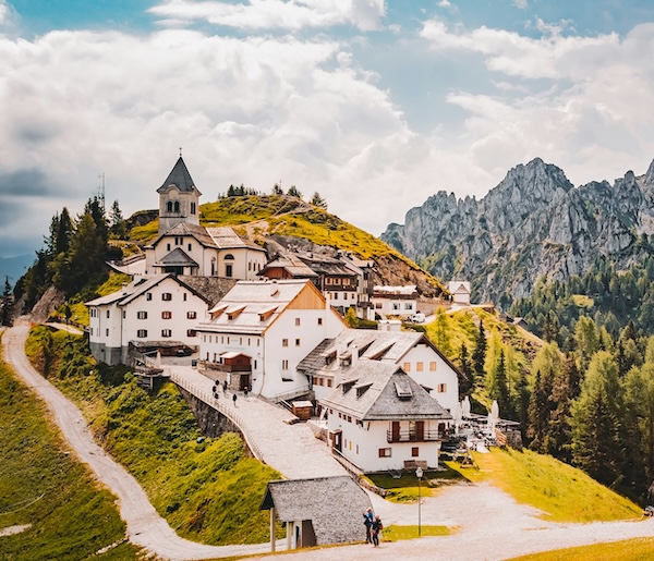 The hilltop village and sanctuary of Monte Lussari with alpine peaks in the background.